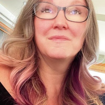 A photo of Lisa with pink highlights and glasses.