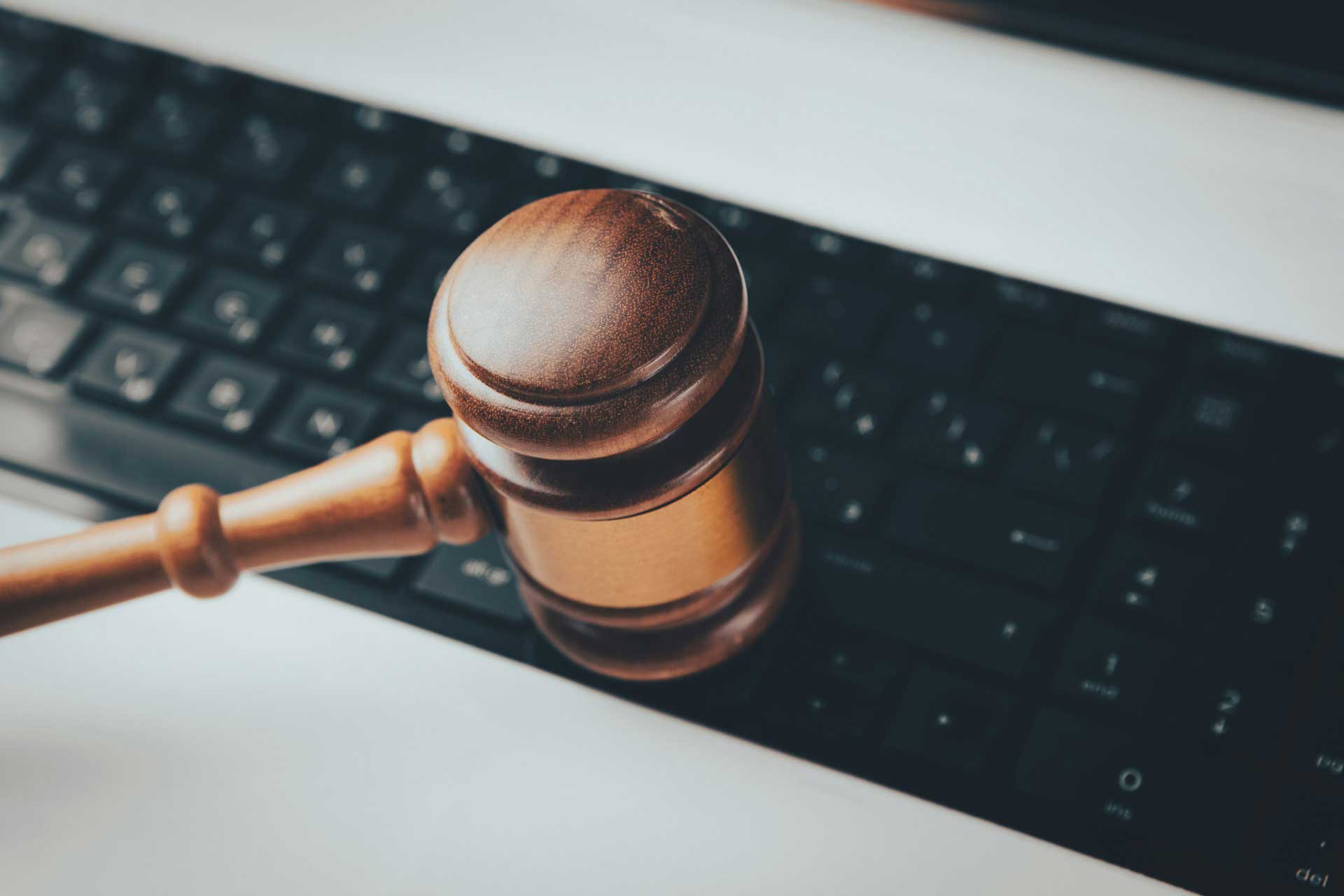 A wooden gavel resting on a black computer keyboard.