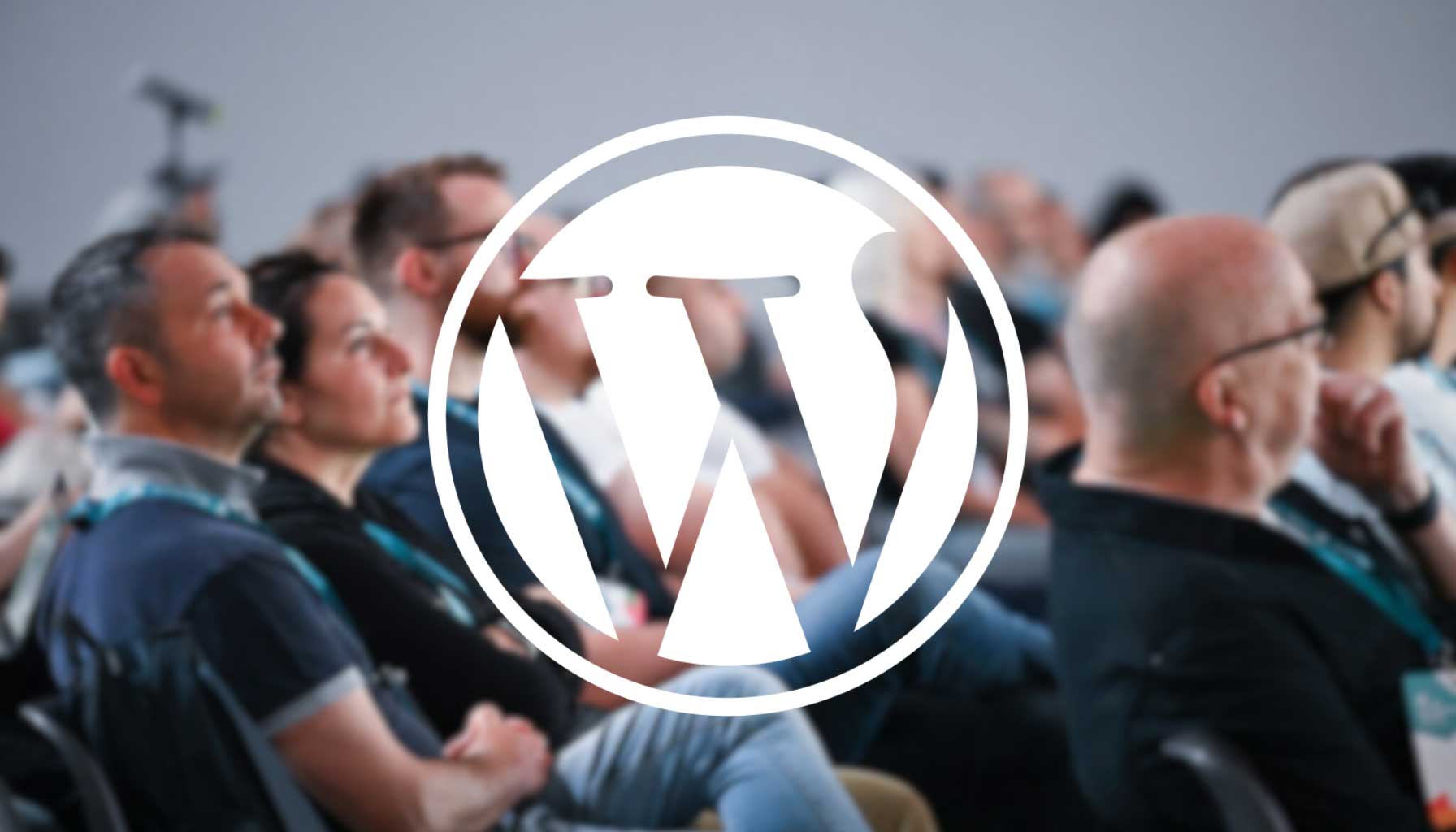 A blurred audience at an event with a prominent WordPress logo overlay.